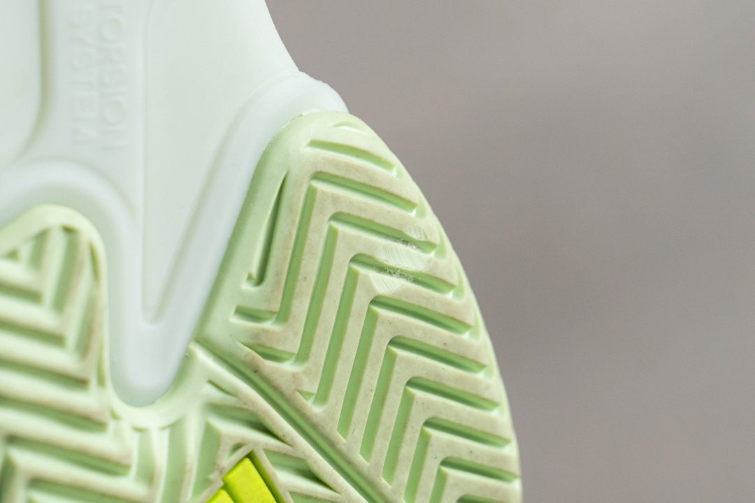 Worn tennis shoe outsole after regular play on synthetic grass