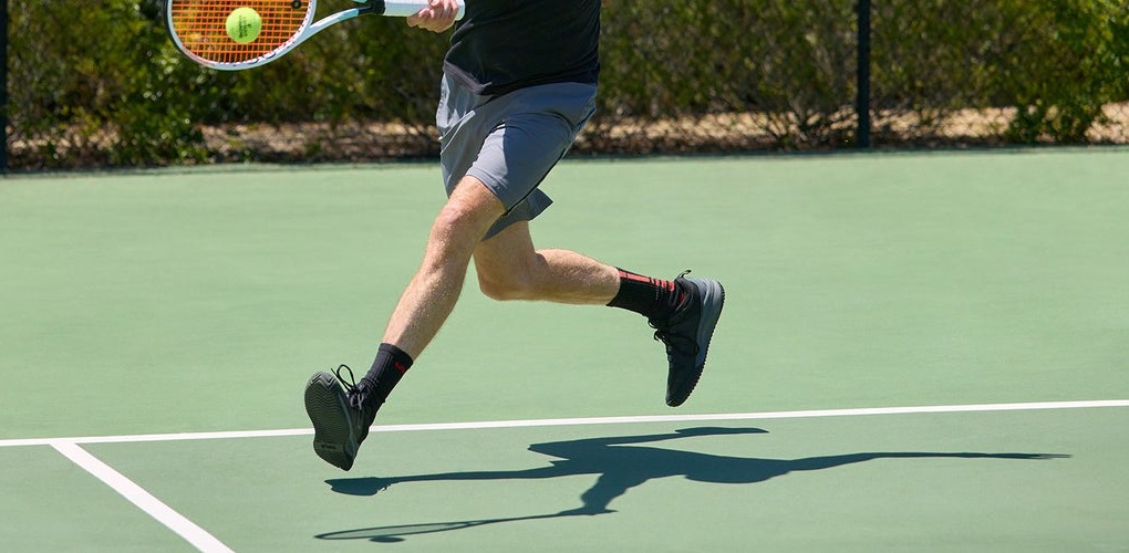 Durable herringbone outsole gripping a sand-filled astro turf court