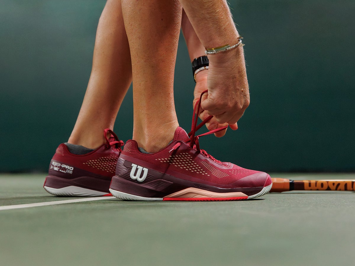 Sock-like bootie tennis shoe locked down for fast movement on astro turf