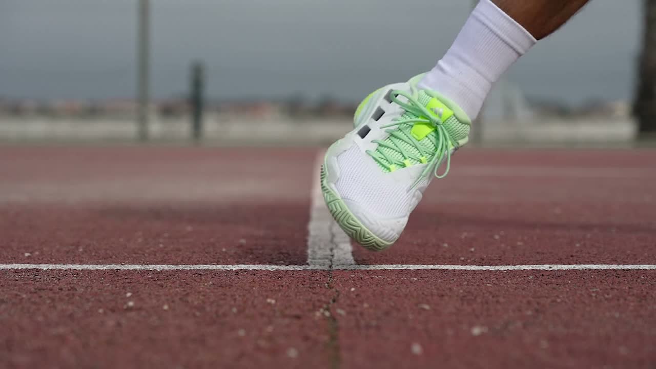 Player pushing off hard sideways in stable tennis shoes on court