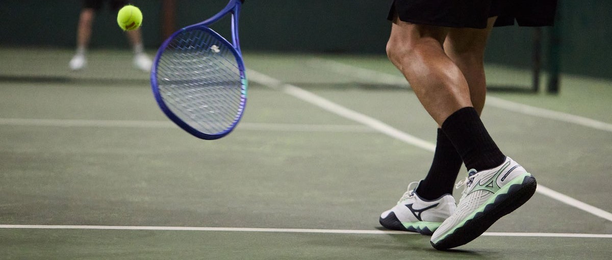 Player landing comfortably after a serve in cushioned tennis shoes