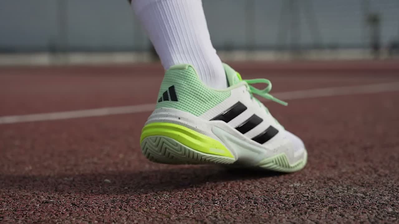 Heel strike of an adidas court shoe on a red hard court